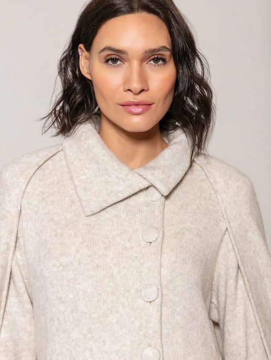 BLUSA ALONGADA COM CAPA REMOVÍVEL TRANSPASSADA E FECHAMENTOS EM BOTÕES BIAMAR